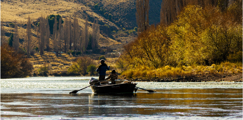 Two people in a boat on a lake, fishing